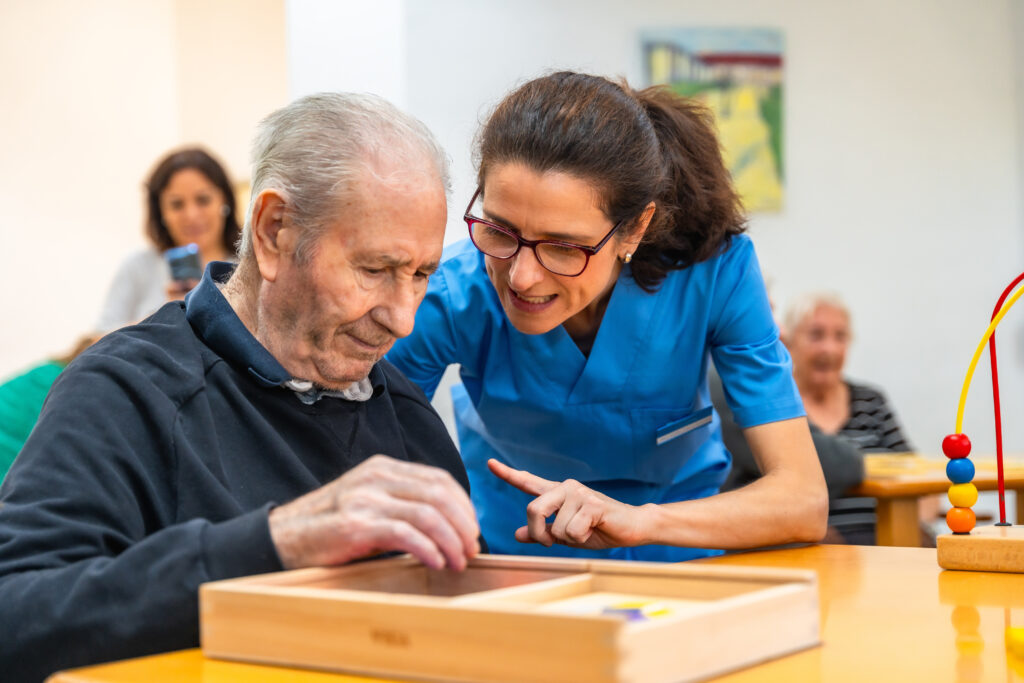 Adult day professional helps senior with interactive puzzle